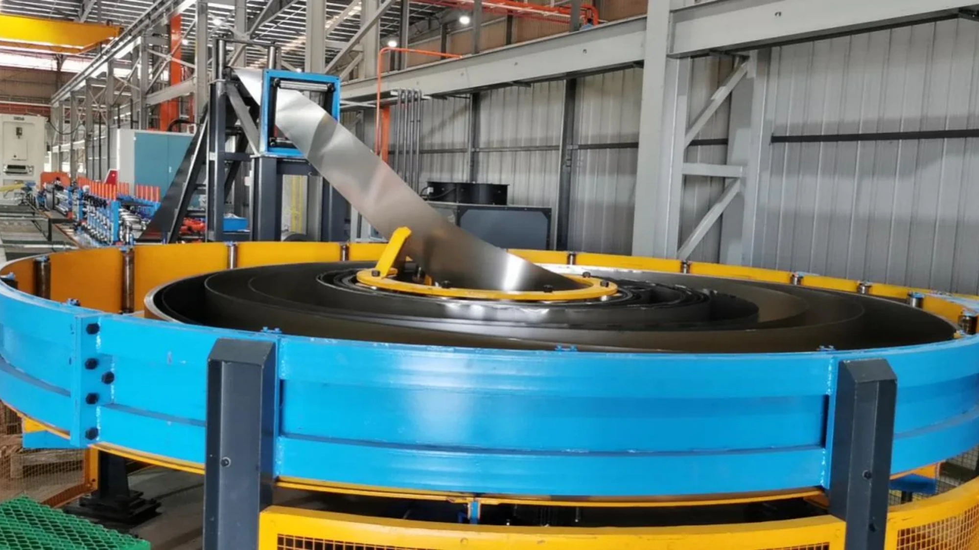 Spiral coil accumulator keeping the mill running through a coil change