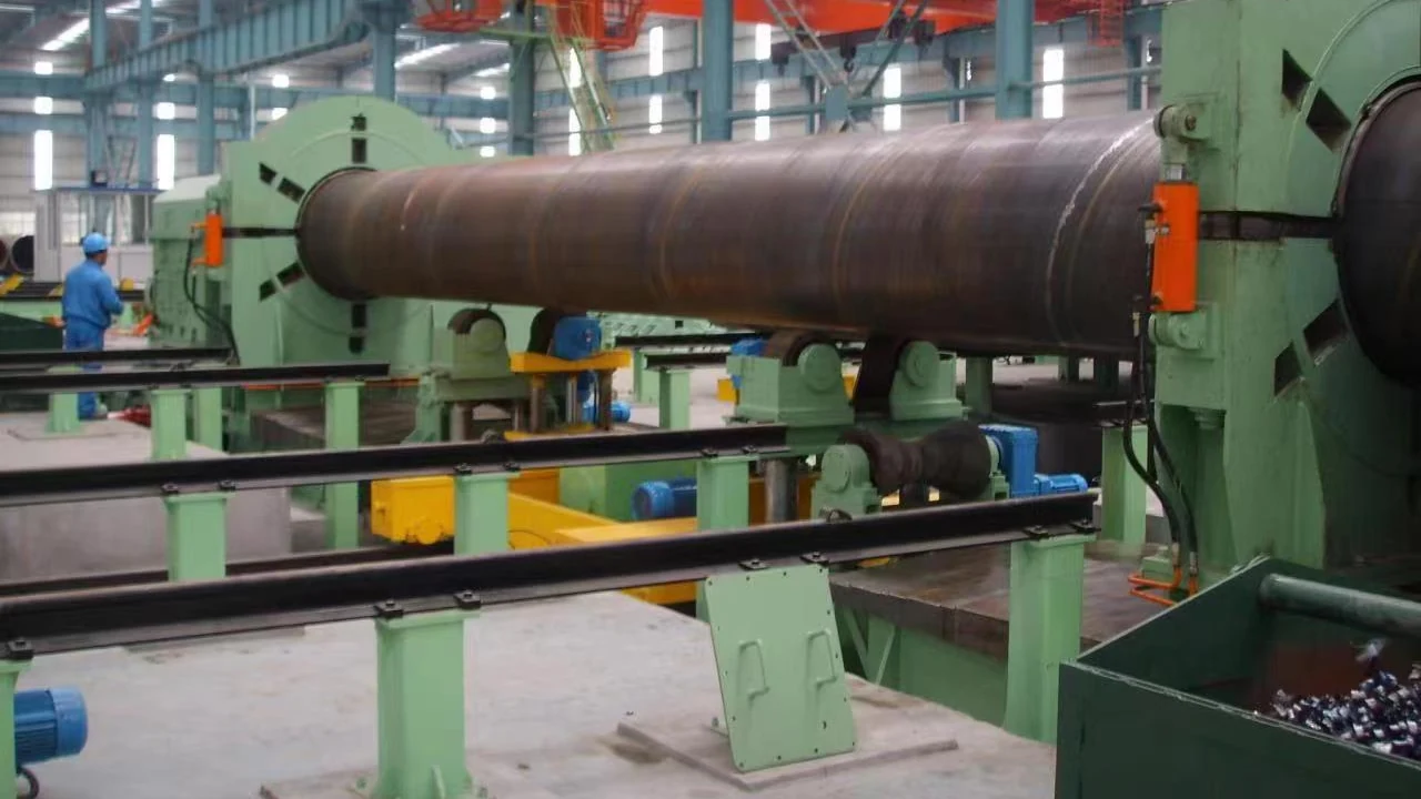 Spiral welded pipe held between the end heads of the hydrostatic tester