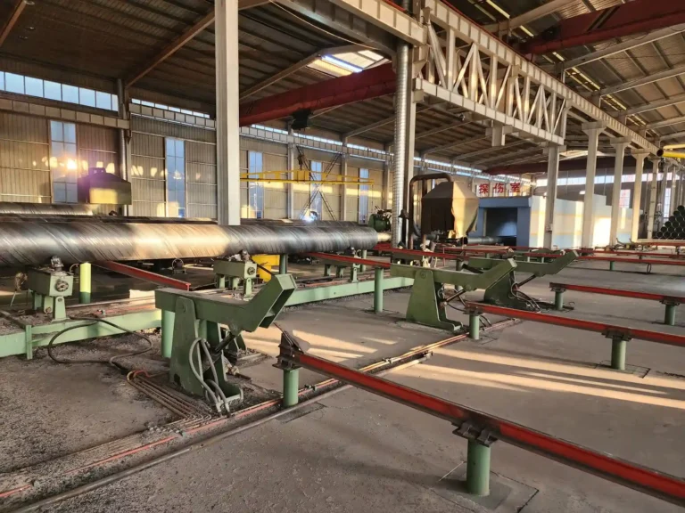 Spiral welded pipe mill and run-out table in the workshop