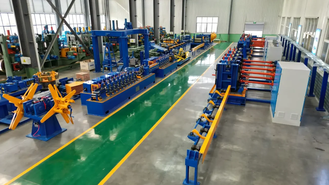 Complete tube mill line from uncoiler to run-out table along a green workshop aisle