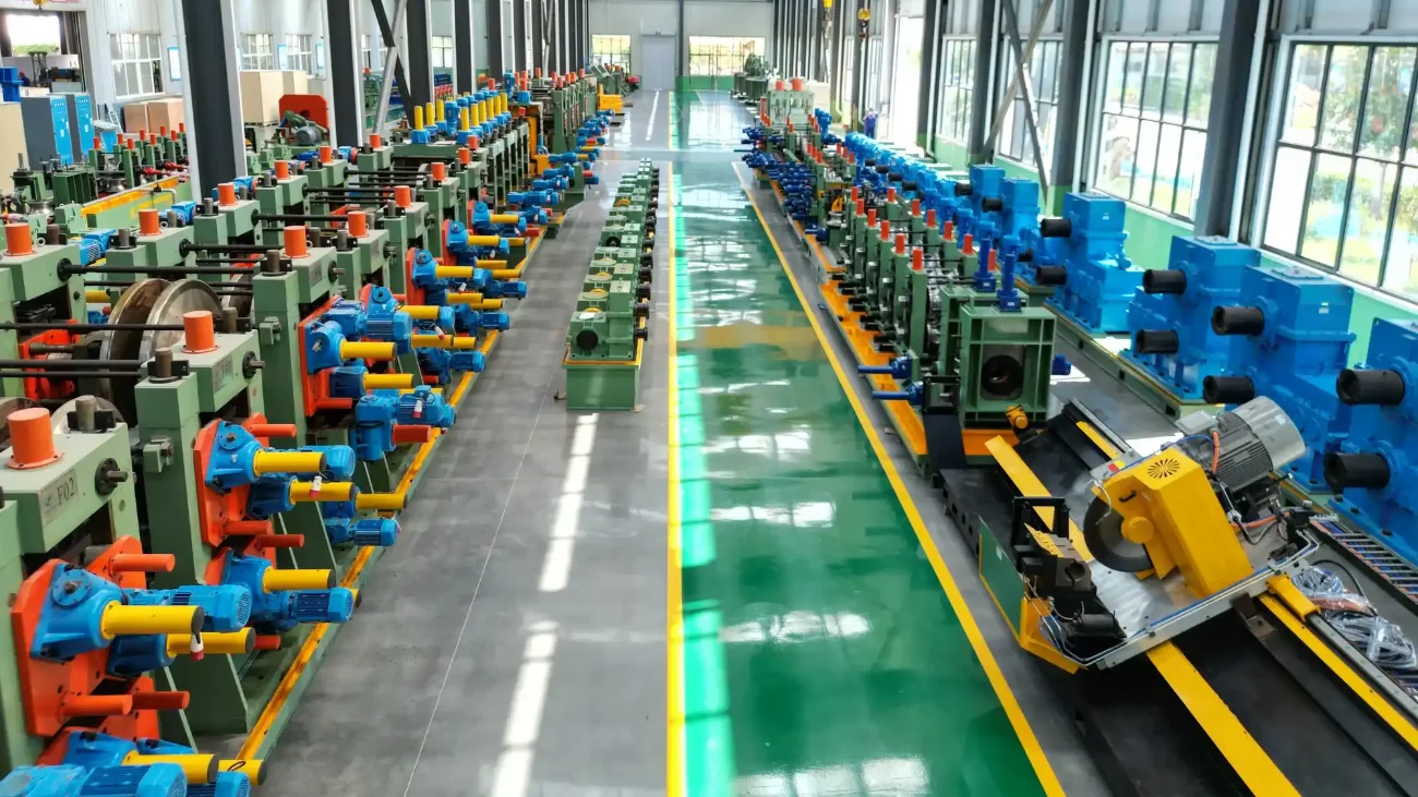 Two rows of tube mill lines either side of a green workshop aisle
