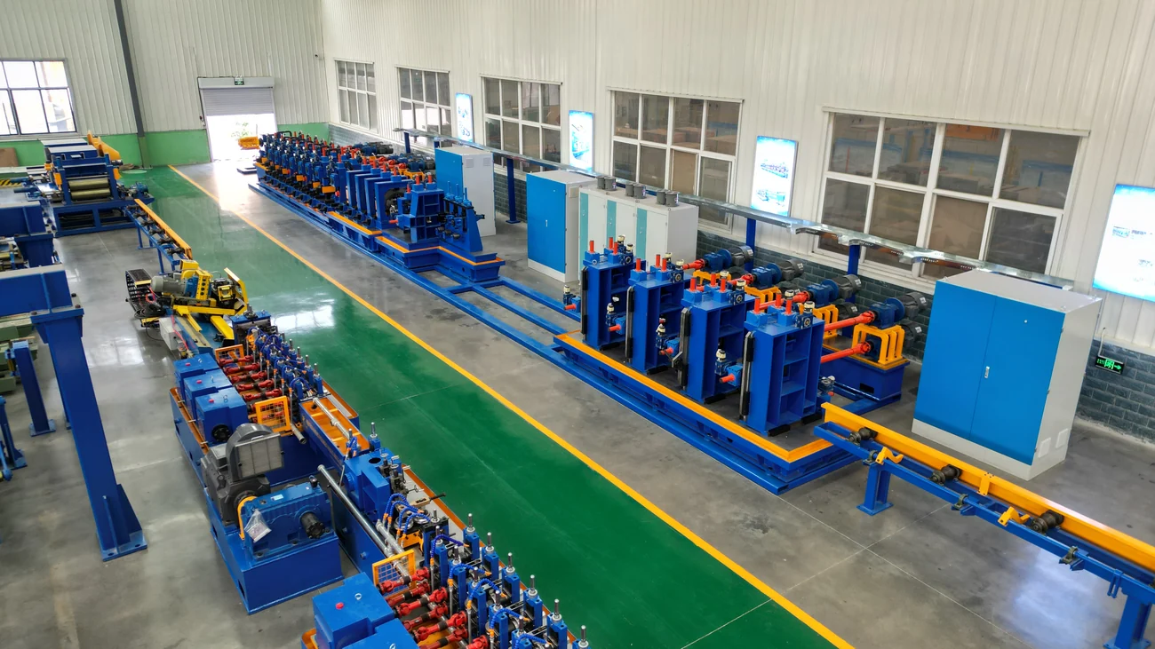 Two welded tube mill lines side by side in a white-walled workshop
