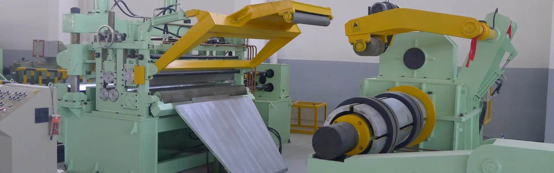 Steel coil on the uncoiler of a slitting line, strip running into the slitter